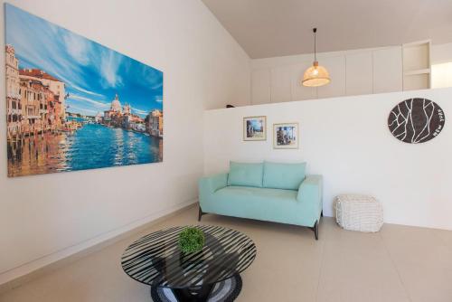 a living room with a blue couch and a table at The Fifty Condo in Heraklio Town