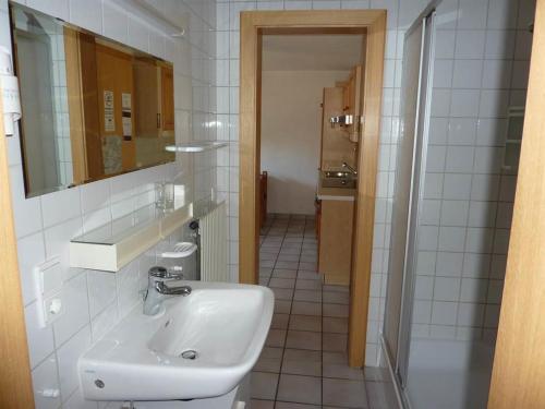 ein weißes Badezimmer mit einem Waschbecken und einem Spiegel in der Unterkunft Haus am Wasserfall in Sankt Anton im Montafon