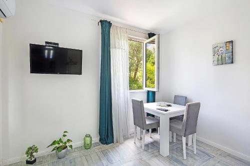 a dining room with a table and chairs and a window at Olive natural in Ðuranovići