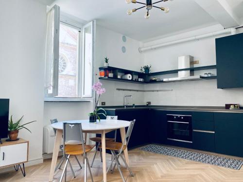uma cozinha com armários azuis e uma mesa e cadeiras em WANDERLUST Splendido appartamento in centro em Pavia