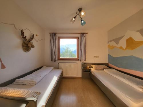 a bedroom with two beds and a window at Wohnung Weitsicht Ruhpolding, 3 Schlafzimmer, Bergpanorama, Alleinlage in Ruhpolding