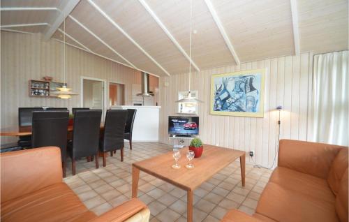 a living room with a table and chairs and a kitchen at Beautiful Home In Nakskov With Sauna in Nakskov