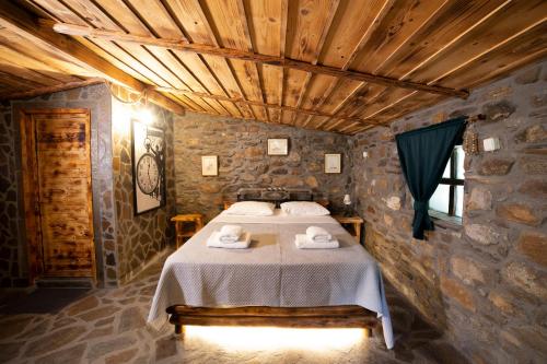 um quarto com uma cama num quarto de pedra em Captain Ikaros em Agios Kirykos