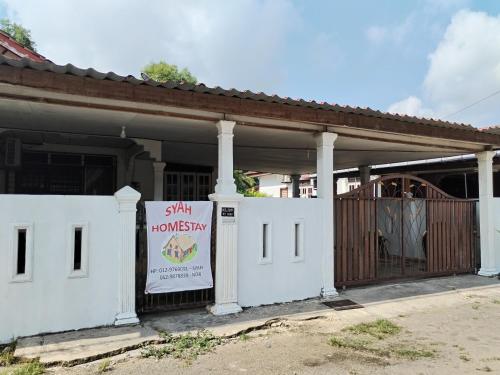 a white house with a sign in front of it at Syah Homestay in Dungun