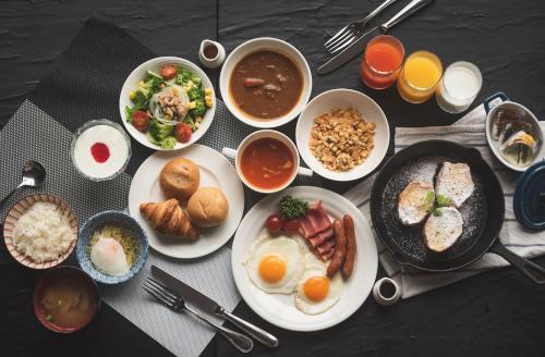 une table avec des assiettes et des bols de nourriture dans l'établissement Kisarazu Washington Hotel, à Kisarazu