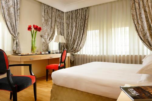 a hotel room with a bed and a desk at FH55 Grand Hotel Palatino in Rome
