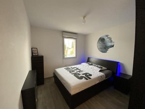 - une chambre dotée d'un lit avec des lumières bleues dans l'établissement Le Skywalker : T2 avec parking & balcon, à Toulouse