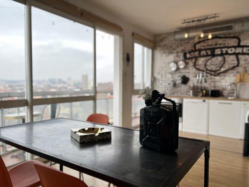 einen Tisch mit einer Vase und einer Schachtel darauf in der Unterkunft Le Brooklyn - T2 à Compans avec vue remarquable in Toulouse