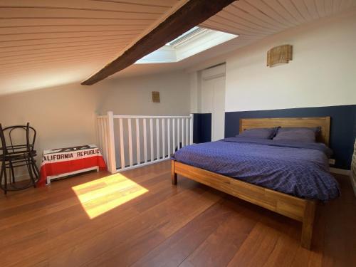 - une chambre avec un lit et une couette bleue dans l'établissement Le Saint Cyp - Briques et Charme à Toulouse, à Toulouse