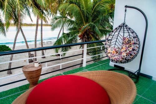 a balcony with a hammock and a swing and the beach at Dhonfulhafi Beach View in Maalhos