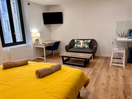 une chambre avec un lit jaune et une chaise dans l'établissement Les appartements du Palais, à Carcassonne