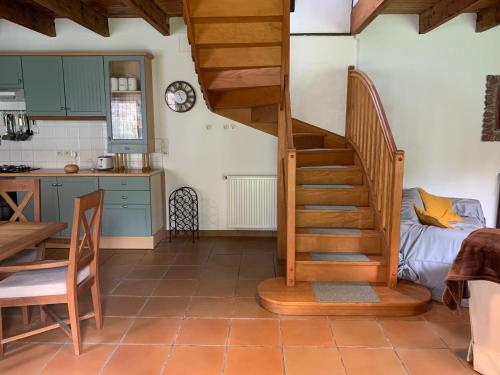 a kitchen with a spiral staircase in a room at Cornouaille / Domaine la Blanche Hermine in Plounérin