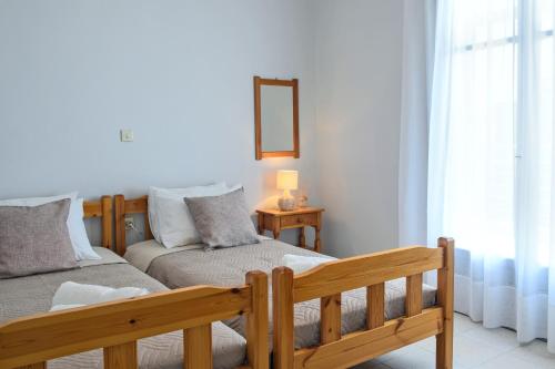 a bedroom with a wooden bed and a couch at VIRI VIRI APARTMENTS in Lilikás