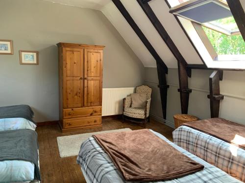 a attic bedroom with two beds and a skylight at Cornouaille / Domaine la Blanche Hermine in Plounérin