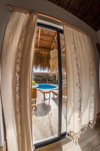 a room with a window with a view of a pool at Hotel Boutique Beso de Sal in Colán
