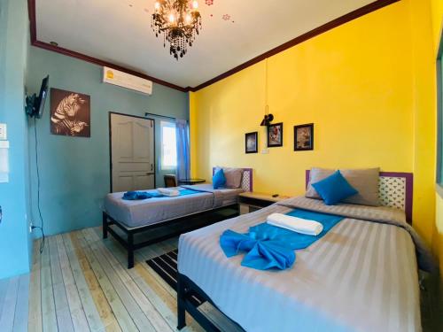 a bedroom with two beds with blue bows on them at Paksina Hotel in Narathiwat