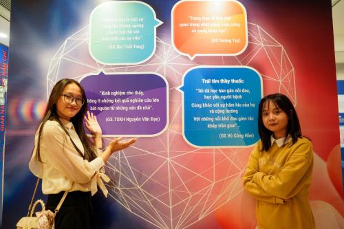 two women standing in front of a wall with speech bubbles at MEDDOM Park in Cao Phong