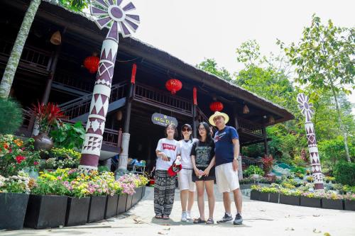 a group of people standing in front of a building at MEDDOM Park in Cao Phong