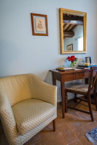 a desk with a chair and a table with a mirror at Hotel & SPA L'Antico Forziere in Deruta