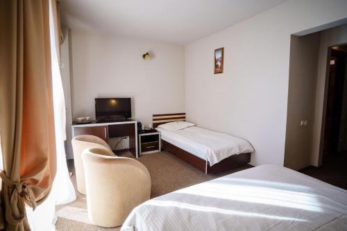 a hotel room with two beds and a television at Bacolux Diana, Herculane in Băile Herculane