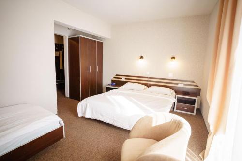 a hotel room with two beds and two chairs at Bacolux Diana, Herculane in Băile Herculane