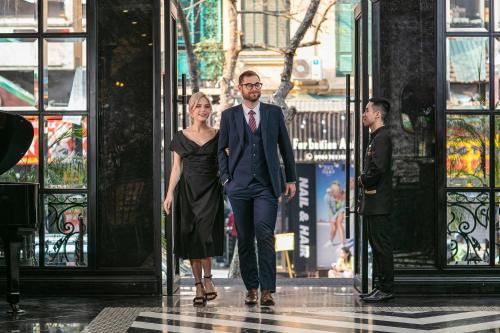 a man and a woman walking through a doorway at La Sinfonía Majesty Hotel and Spa in Hanoi