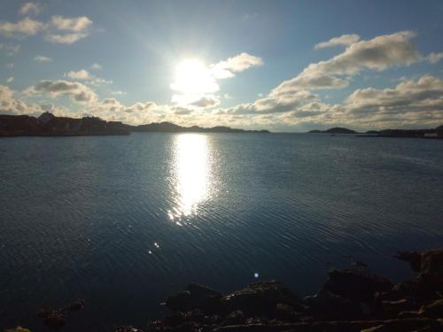 um pôr do sol sobre uma grande massa de água em West coast villa with sea view em Skärhamn