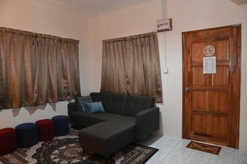 a living room with a couch and a door at KRPV Homestay in Tambunan