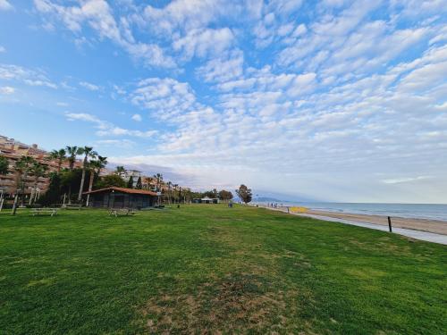 a park next to the beach under a cloudy sky at Holiday Deluxe Apartment Miramar Magic World in Oropesa del Mar