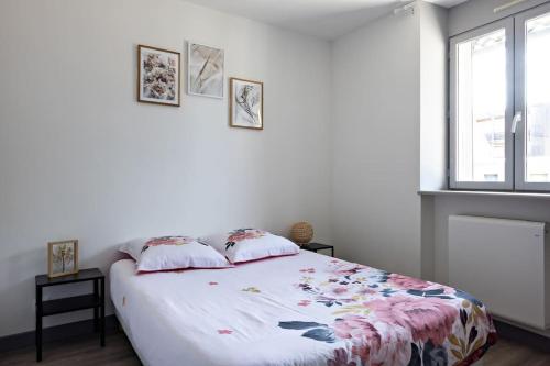 - une chambre dotée d'un lit avec un couvre-lit floral dans l'établissement Le Petit Tyard, à Chalon-sur-Saône