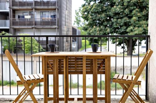 d'une table en bois et de deux chaises sur un balcon. dans l'établissement Le Petit Tyard, à Chalon-sur-Saône