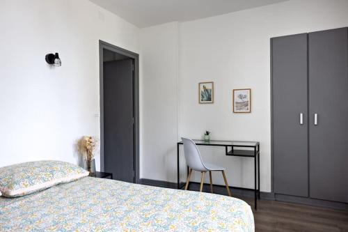 - une chambre avec un lit, un bureau et une chaise dans l'établissement Le Petit Tyard, à Chalon-sur-Saône