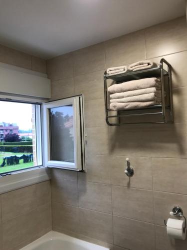 a bathroom with a tub and a window and towels at Apartamentos Olga Cantabria in Polanco