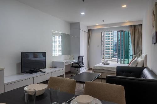 a living room with a bed and a room with a television at MyRehat Suites Bukit Ceylon in Kuala Lumpur