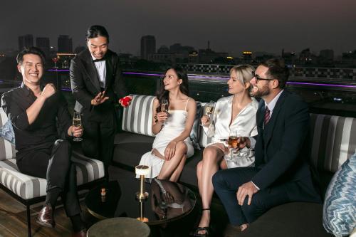 a group of people sitting on a balcony at a party at La Sinfonía Majesty Hotel and Spa in Hanoi