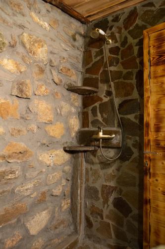 a stone wall with a shower in a bathroom at Captain Ikaros in Agios Kirykos