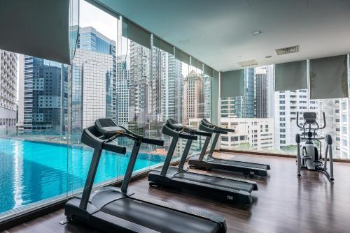 a gym with three treadmills and a large window at MyRehat Suites Bukit Ceylon in Kuala Lumpur