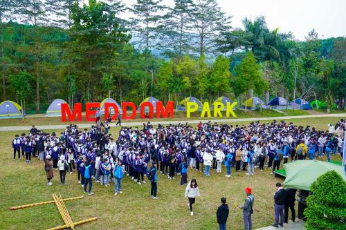 a large crowd of people walking in a park at MEDDOM Park in Cao Phong