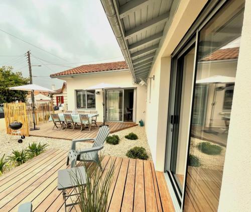 eine Terrasse mit Stühlen und Tischen auf einem Haus in der Unterkunft Villa de l'Aiguillon in Arcachon