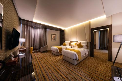 Habitación de hotel con 2 camas y TV en AlRayah Hotel en Jazan