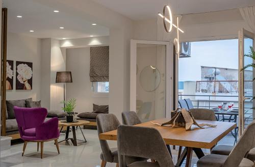 a living room with a table and purple chairs at CHE BELLO LUXURY APARTMENTS in Preveza