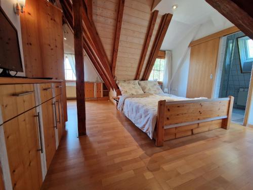 a bedroom with a bed in a room with wooden walls at Hotel Aurichs in Meersburg