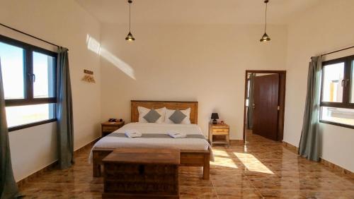 a bedroom with a bed and two windows at SAMA Jabal Samhan Hotel in Salalah