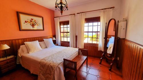 a bedroom with a bed and a mirror and windows at Manuela in Fuencaliente de la Palma