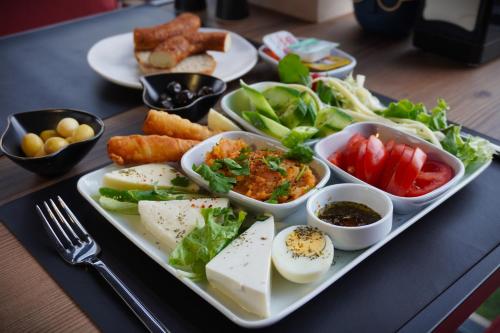 un plato de comida con huevos y verduras en una mesa en ReynaBe Boutique Hotel, en Dikili