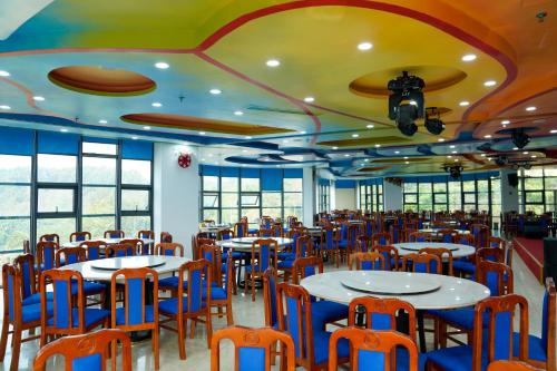 a dining room with tables and blue chairs at MEDDOM Park in Cao Phong