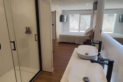 une salle de bain avec un lavabo et une douche et un lit dans l'établissement T3 cosy et climatisé avec vue montagne, à Moustajon