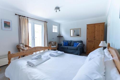 1 dormitorio con 1 cama grande y toallas. en Tankerton Town House, 1 parking space, 150m beach, en Whitstable
