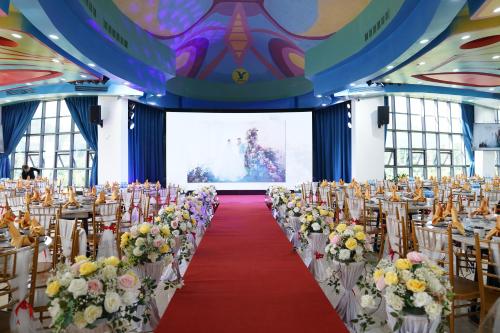 a room with rows of tables and chairs with flowers at MEDDOM Park in Cao Phong