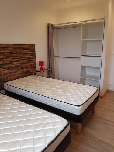 - une chambre avec un lit et un placard avec des étagères dans l'établissement 05 - Très joli 3 pièces neuf 2 chambres, logement tout équipé pour 1 à 4 personnes maximum, vue sur jardin avec parking privatif, grand fourgon possible, tout le linge de maison est fourni, à Annesse-et-Beaulieu